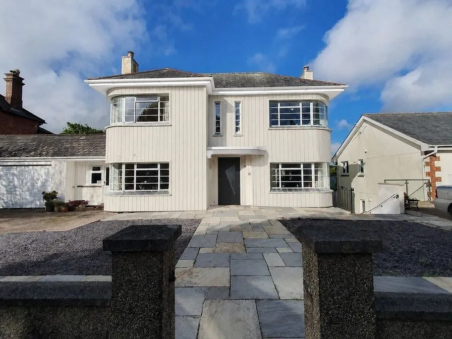 The same house as an AI concept clad in pale vertical boards with a charcoal front door