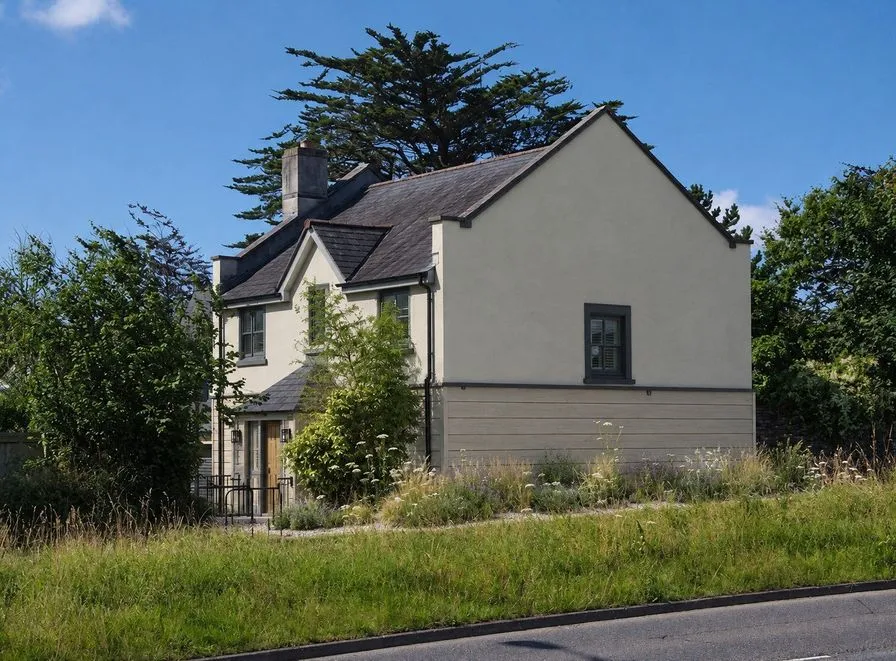 The same house as an AI concept with pale gray stucco, soft gray lower siding and charcoal window frames