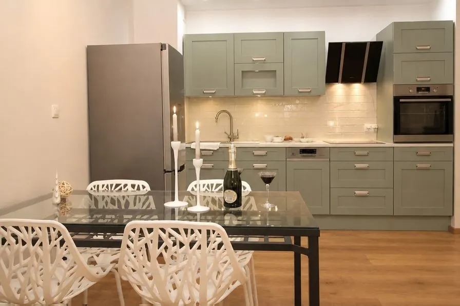 The same kitchen as an AI concept with sage shaker cabinets, ivory tiles and an oak floor