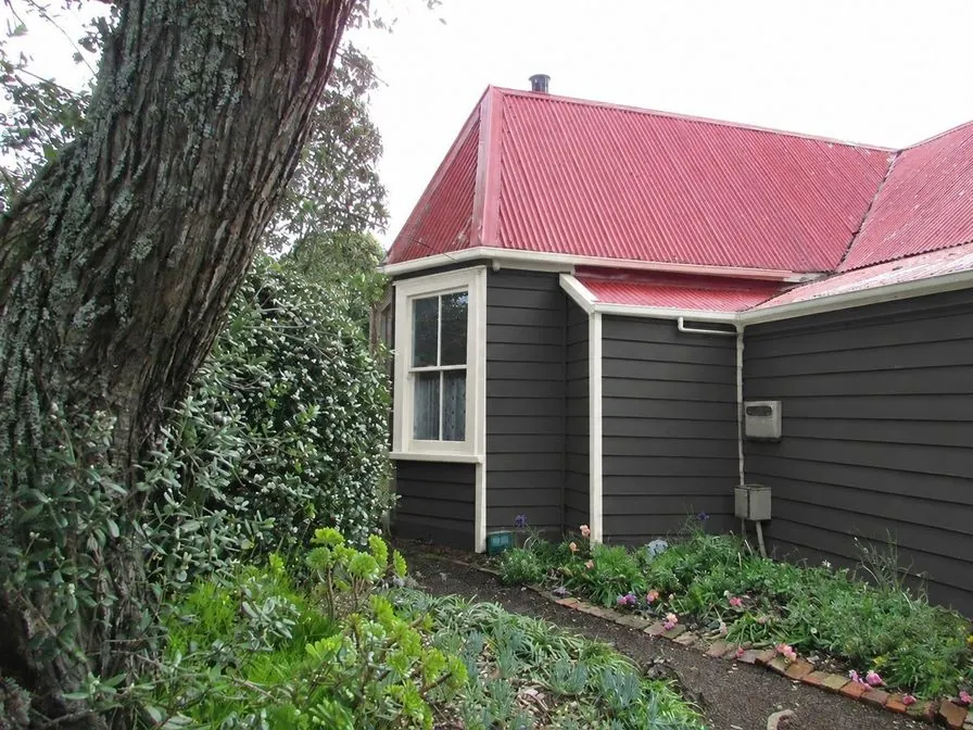 The same cottage as an AI concept with charcoal clapboards and white trim