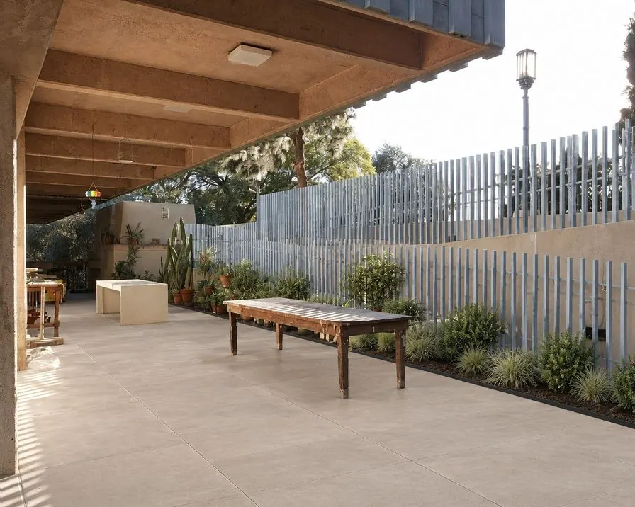 The same covered patio as an AI concept with pale stone paving and planted borders